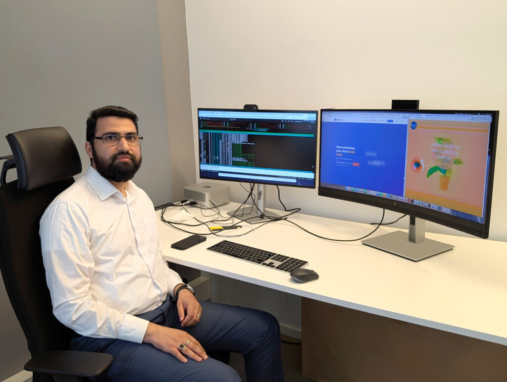 Akif Quddus Khan in front of two computer screens.
